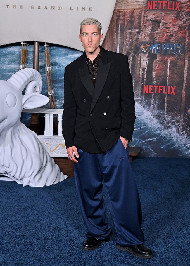 Taz Skylar tampil beda dengan rambut plontos pirang. Pemeran Sanji ini bergaya parlente dalam setelan tuxedo dan baggy pants biru. Foto: Getty Images