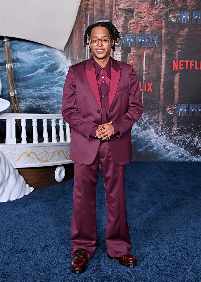 Pemeran Usopp, Jacob Romero Gibson, tampil nyentrik mengenakan setelan burgundy yang senada dengan sepatunya. Foto: Getty Images