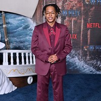 Pemeran Usopp, Jacob Romero Gibson, tampil nyentrik mengenakan setelan burgundy yang senada dengan sepatunya. Foto: Getty Images