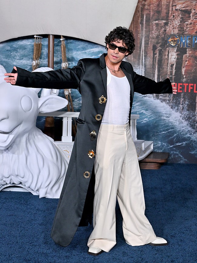 Inaki Godoy, pemeran Monkey D. Luffy, mengenakan singlet dan baggy pants dipadu coat panjang yang memberi kesan edgy. Foto: Getty Images