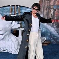 Inaki Godoy, pemeran Monkey D. Luffy, mengenakan singlet dan baggy pants dipadu coat panjang yang memberi kesan edgy. Foto: Getty Images