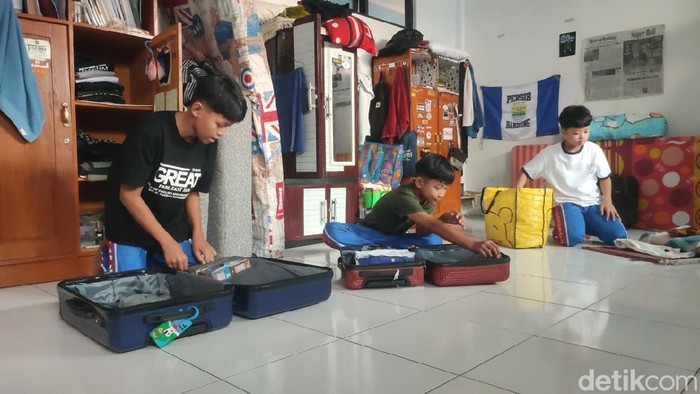 Santri Ponpes Darussalam Ciamis sedang berkemas membereskan baju ke koper karena akan mudik lebih awal.