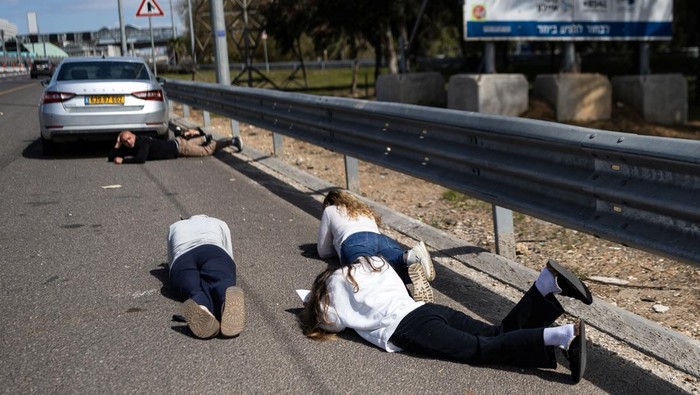 Sirene peringatan berbunyi di Israel tengah saat rentetan rudal dari Iran berdatangan. Warga yang berada di jalan segera tiarap untuk berlindung. REUTERS/Itai Ron
