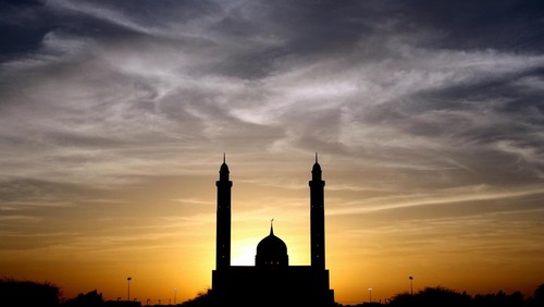 Siluet masjid sore hari.