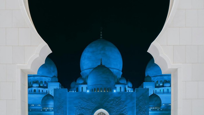 Ilustrasi masjid berwarna biru dengan latar belakang langit malam.
