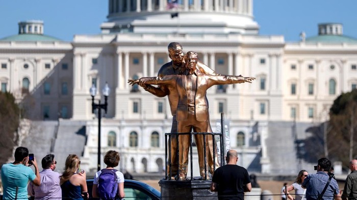 Instalasi seni “King of the World” yang menampilkan figur Donald Trump dan Jeffrey Epstein muncul di National Mall, Washington, dan menarik perhatian warga. REUTERS/Evelyn Hockstein