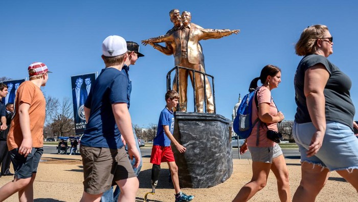 Instalasi seni “King of the World” yang menampilkan figur Donald Trump dan Jeffrey Epstein muncul di National Mall, Washington, dan menarik perhatian warga. REUTERS/Evelyn Hockstein