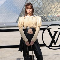 Koleksi Louis Vuitton Fall/Winter 2026 yang dikenakan Lisa terdiri dari crop top berwarna butter yellow dan leather pants hitam. Atasan yang dikenakannya memiliki sentuhan unik. Ada dua ikat pinggang, dengan atasan hitam panjang terbuka di bawahnya, memperlihatkan pusarnya. Foto: dok. X