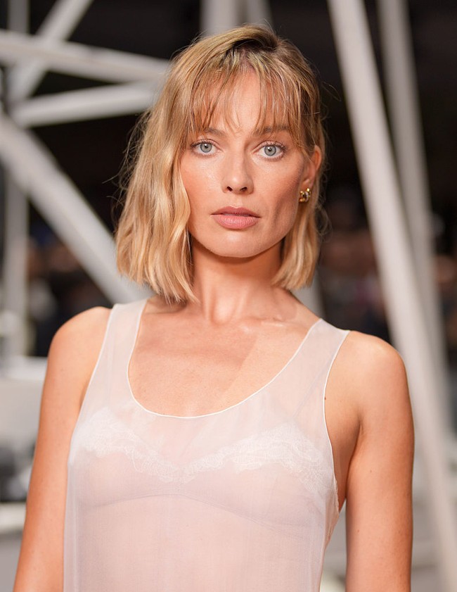 Rambut barunya ditata sedikit berantakan dengan poni pendek yang jatuh tepat di atas alis. Meski lebih pendek, warna pirang khasnya tetap dipertahankan, dengan highlight keemasan yang memberi dimensi alami pada rambutnya. Foto: WWD via Getty Images/WWD