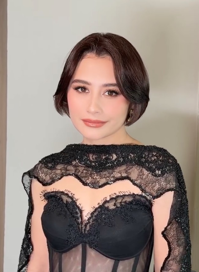 Rambutnya ditata pendek sebahu dengan gaya sleek bob dan belahan tengah. Sementara riasannya tampak flawless dengan smokey eyes yang tegas serta lipstik nude pink hasil tangan MUA Vinki Hanafi. Foto: Instagram/@prillylatuconsina96