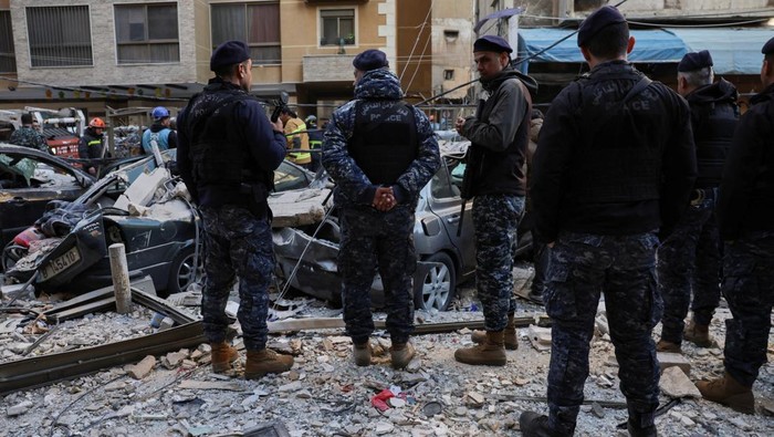 Emergency personnel stand near debris and damaged vehicles at site of an Israeli strike on an apartment building, in central Beirut, Lebanon, March 11, 2026, following an escalation between Hezbollah and Israel amid the U.S.-Israeli conflict with Ira