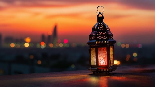 Ornamental Arabic lantern with burning candle glowing at night background. Festive greeting card, invitation for Muslim holy month Ramadan Kareem.