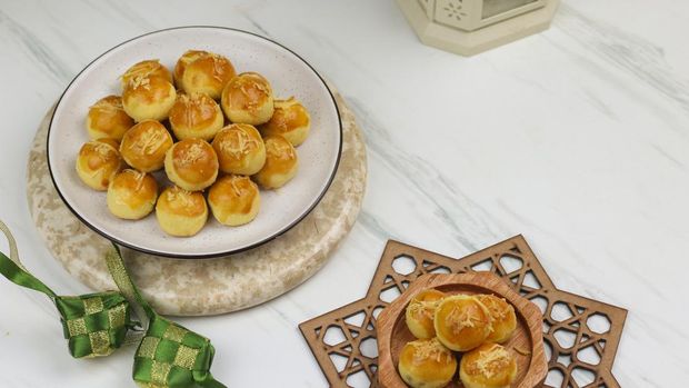 Kue Nastar Nastar cookies, typical of hari raya cookies filled with pineapple jam and garnish with grated cheese. Eid Mubarak concept background with ketupat and Islamic decoration.