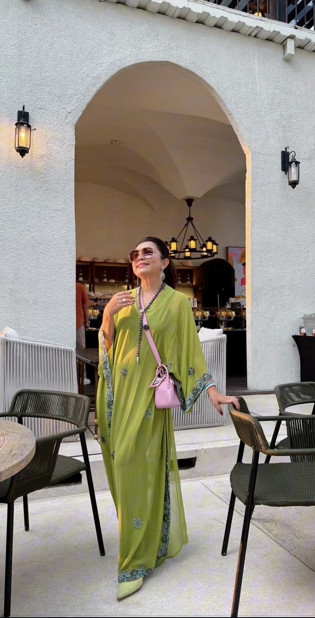 Di kesempatan lain, Mayang juga sempat terlihat mengenakan kaftan hijau yang lebih simpel dengan aksen payet berbentuk bunga. Kontras dengan busana dan sepatunya yang berwarna hijau, Mayang melengkapi penampilannya dengan tas selempang soft pink. Foto: Instagram/@mayangsari_official