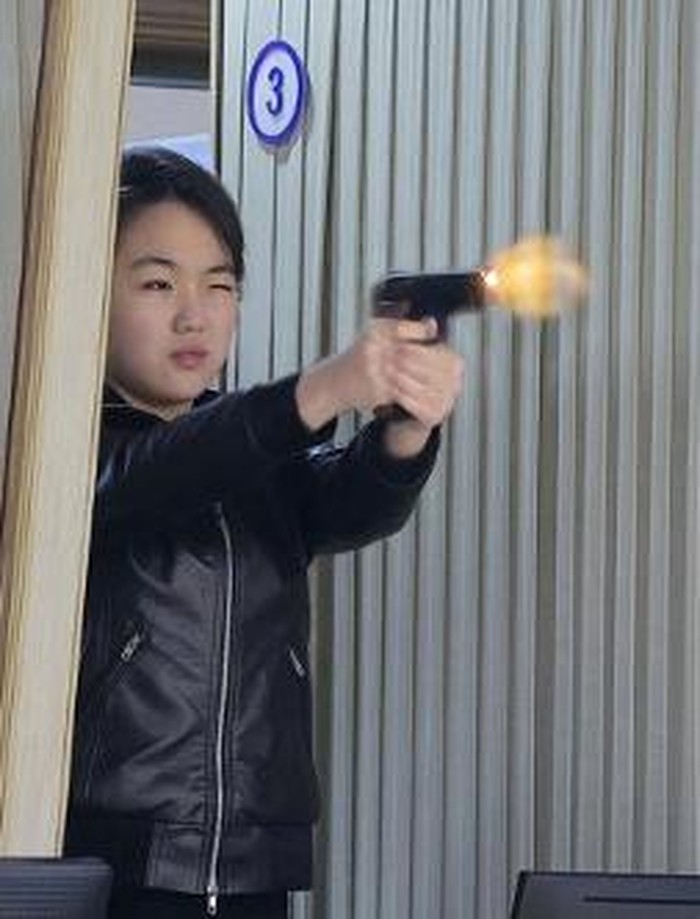 This picture taken on March 11, 2026 and released by North Koreas official Korean Central News Agency (KCNA) on March 12, 2026 shows North Korean leader Kim Jong Uns daughter Kim Ju Ae (2nd R) test-firing a new pistol at a shooting gallery at an im