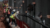 Dalam proses konstruksi, para pekerja terlihat memasang fondasi beton serta rangka baja yang akan menjadi struktur dasar tembok perbatasan. Tahapan ini dilakukan untuk memperkuat konstruksi penghalang yang dibangun di kawasan tersebut. Anadolu via Getty Images/Anadolu