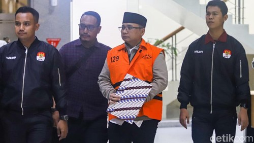 Tersangka kasus dugaan korupsi kuota haji dan penyelenggaraan ibadah haji Yaqut Cholil Qoumas mengenakan rompi tahanan usai menjalani pemeriksaan di Gedung Merah Putih KPK, Jakarta, Kamis (12/3/2026). Ia berusaha menutupi borgol menggunakan map. KPK menahan mantan Menteri Agama periode 2020-2024 Yaqut Cholil Qoumas atas kasus dugaan korupsi kuota haji dan penyelenggaraan ibadah haji yang merugikan keuangan negara sekitar Rp622 miliar.