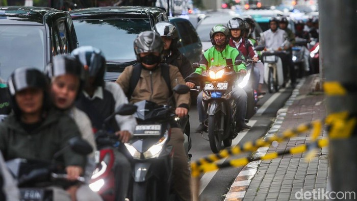 Sejumlah warga menunggu pengemudi ojek online di kawasan Jalan Rasuna Said, Kamis (12/3/2026), di tengah keluhan lamanya waktu tunggu layanan transportasi daring.