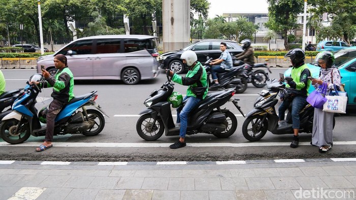 Sejumlah warga menunggu pengemudi ojek online di kawasan Jalan Rasuna Said, Kamis (12/3/2026), di tengah keluhan lamanya waktu tunggu layanan transportasi daring.