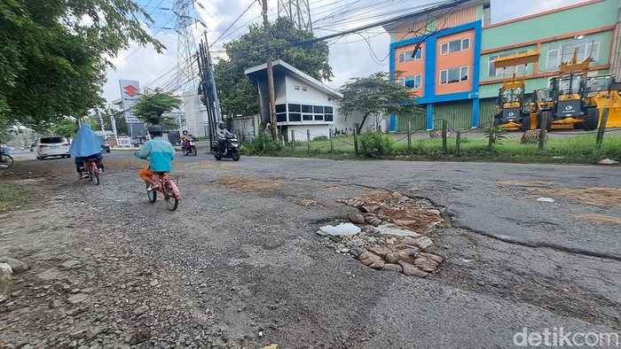 Warga tambal jalan berlubang dengan batok kelapa di Kertomenanggal Surabaya