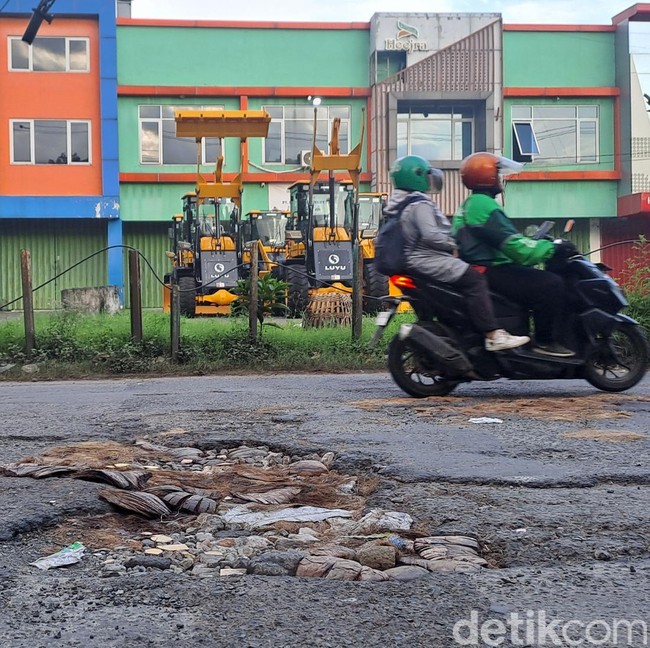 Perbaikan Jalan Berlubang Lamban, Warga Tambal dengan Batok Kelapa