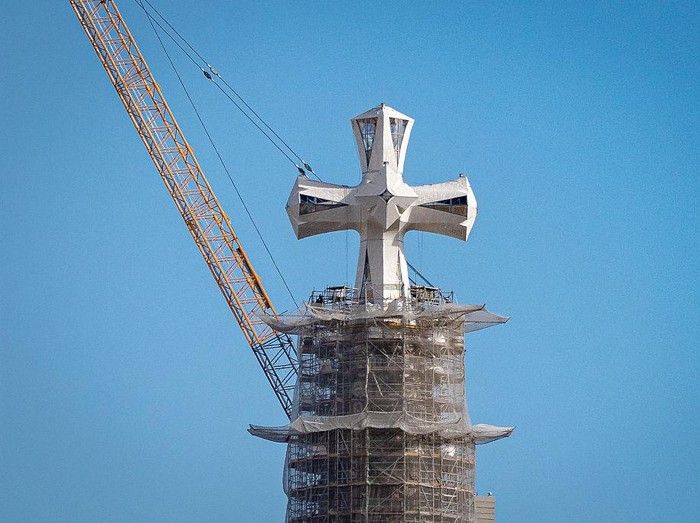 The cross crowning the central Tower of Jesus Christ at Sagrada Familia is seen above the skyline of Barcelona, Spain, on March 9, 2026. The installation of the final elements of the cross marks the completion of the tower designed by Antoni Gaudi, b