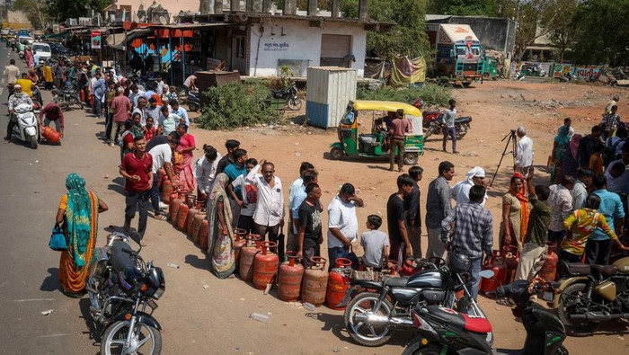 People stand in a queue with their empty LPG cylinders outside a gas agency amid supply disruptions following the U.S.-Israeli conflict with Iran, in Ahmedabad, India, March 12, 2026. REUTERS/Amit Dave     TPX IMAGES OF THE DAY
