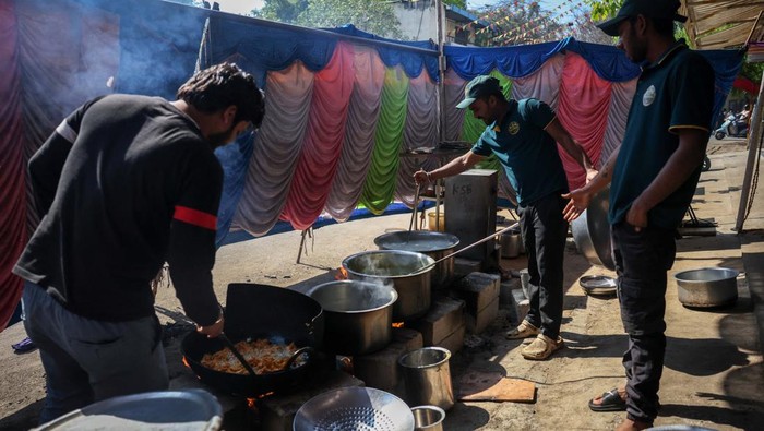 Workers cook food using firewood instead of cooking gas outside a restaurant amid disruptions in commercial LPG supply, following the U.S.-Israeli conflict with Iran, in Bengaluru, India, March 12, 2026. REUTERS/Priyanshu Singh