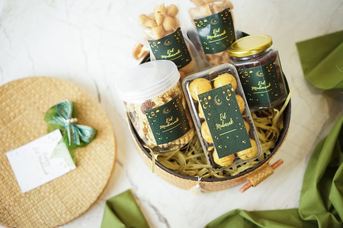 Ramadhan gift. Hampers moslem theme for celebrete the holy, bake snack, nastar, bakery, cookies, pudiing, chococips, roll cake, castangel.with greeting card and green accessories on white background