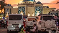 Sebagian pemudik terlihat berbuka puasa secara sederhana di area parkir dengan menggelar alas di samping kendaraan.