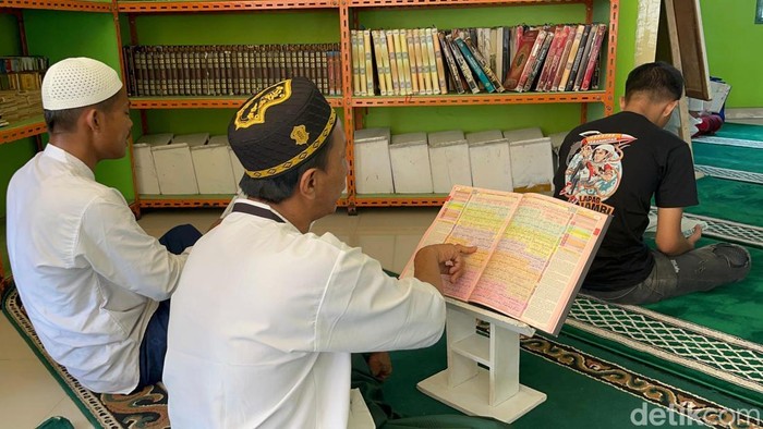 Reza membuka Al-Quran dan membacanya dari blok tahanan yang dia tempati di Lapas Kelas IIA Jambi
