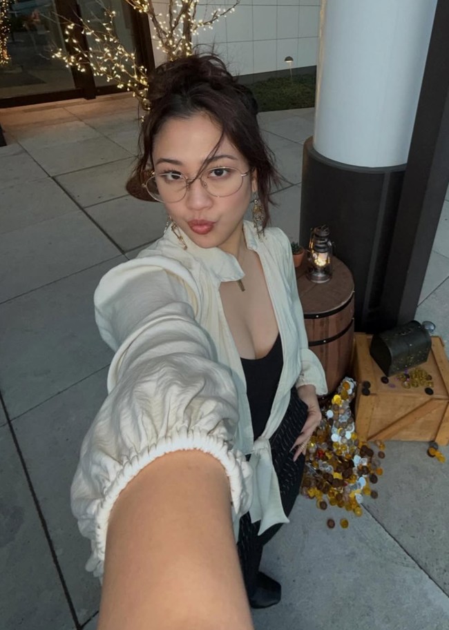 Sherina memilih blouse putih berbahan ringan dengan potongan lengan panjang yang sedikit mengembang. Modelnya terlihat santai namun tetap memberikan kesan feminin dan elegan. Foto: Instagram/@sherinamunaf