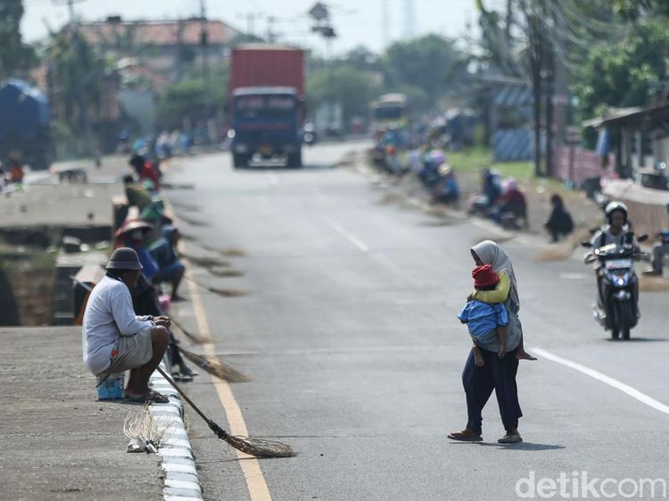 Bahaya Mengancam, Penyapu Koin Bawa Anak di Jembatan Kali Sewo