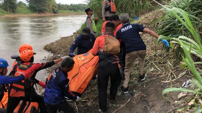Petugas mengevakuasi mayat diduga pemilik motor di di Jembatan Ngrame, Pungging Mojokerto