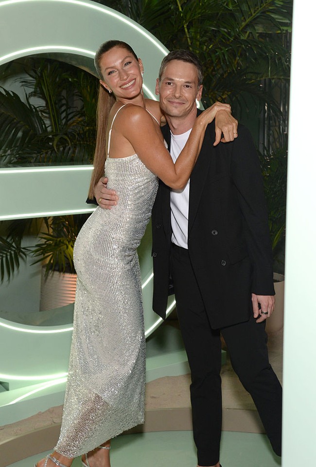 Gisele tampil elegan dalam slip dress berpayet perak dengan garis leher persegi dan siluet yang mengikuti lekuk tubuhnya. Gaun dengan tali spaghetti itu jatuh hingga di atas pergelangan kaki dan memperlihatkan sepatu hak tinggi bertali yang juga berkilau. Foto: Getty Images for Garnier/Michael Simon