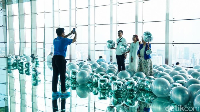 Pengunjung melihat pameran seni bertajuk “Mirror & Lights” yang digelar oleh Ganara Art bersama UPfinity di Thamrin Nine, lantai 85, Jakarta, Sabtu (14/3/2026). Kegiatan ini mengajak pengunjung menikmati pengalaman seni di ketinggian dengan latar panorama ibu kota.