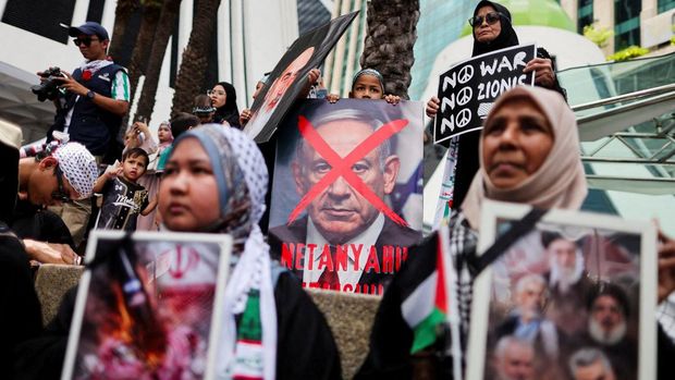 Para pendukung pro-Palestina mengibarkan bendera Palestina dan membawa replika Masjid Al-Aqsa selama unjuk rasa ke Kedutaan Besar AS untuk memperingati Hari al-Quds (Yerusalem), yang diprakarsai oleh Ruhollah Khomeini, pemimpin Revolusi Islam Iran tahun 1979 dan diperingati pada Jumat terakhir bulan puasa Ramadhan untuk menunjukkan solidaritas dengan Palestina dan penentangan terhadap Zionisme, di Kuala Lumpur, Malaysia, Jumat (13/3/2026). (REUTERS/Hasnoor Hussain)