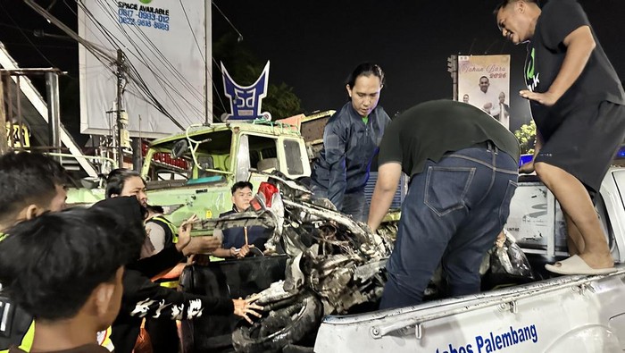 Polisi saat mengevakuasi motor yang ditabrak truk kontainer di Palembang