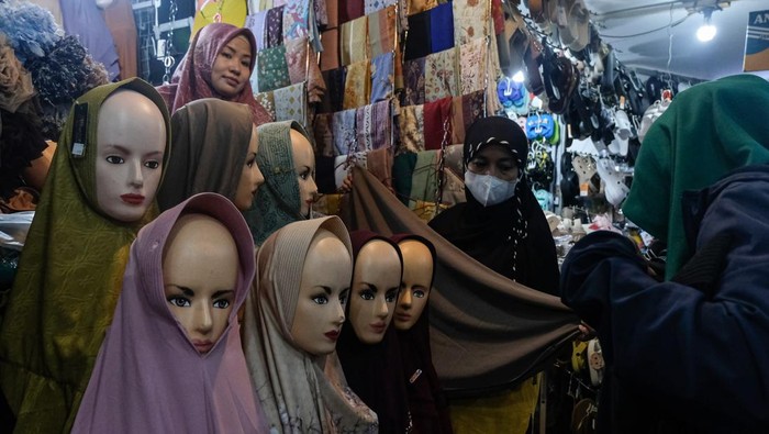 Calon pembeli mencoba busana Muslim yang dijual di Pasar Johar, Semarang, Jawa Tengah, Sabtu (14/3/2026). Menurut pedagang, memasuki H-7 Lebaran penjualan busana muslim seperti mukena, baju gamis, peci, jilbab, sarung, sajadah, dan baju koko yang dijual seharga Rp35 ribu-Rp500 ribu itu mengalami peningkatan sebesar 30 persen dibandingkan hari biasa serta diprediksi akan terus meningkat hingga H-1 Lebaran. ANTARA FOTO/Makna Zaezar/tom.