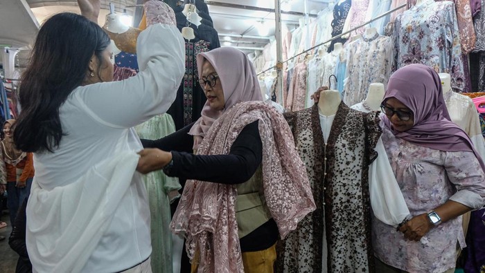 Calon pembeli mencoba busana Muslim yang dijual di Pasar Johar, Semarang, Jawa Tengah, Sabtu (14/3/2026). Menurut pedagang, memasuki H-7 Lebaran penjualan busana muslim seperti mukena, baju gamis, peci, jilbab, sarung, sajadah, dan baju koko yang dijual seharga Rp35 ribu-Rp500 ribu itu mengalami peningkatan sebesar 30 persen dibandingkan hari biasa serta diprediksi akan terus meningkat hingga H-1 Lebaran. ANTARA FOTO/Makna Zaezar/tom.