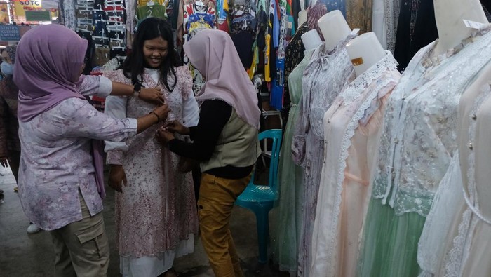 Calon pembeli mencoba busana Muslim yang dijual di Pasar Johar, Semarang, Jawa Tengah, Sabtu (14/3/2026). Menurut pedagang, memasuki H-7 Lebaran penjualan busana muslim seperti mukena, baju gamis, peci, jilbab, sarung, sajadah, dan baju koko yang dijual seharga Rp35 ribu-Rp500 ribu itu mengalami peningkatan sebesar 30 persen dibandingkan hari biasa serta diprediksi akan terus meningkat hingga H-1 Lebaran. ANTARA FOTO/Makna Zaezar/tom.