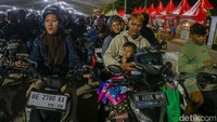 Sejumlah keluarga pemudik mengantre di area pelabuhan sambil menunggu instruksi masuk kapal pada dini hari.  