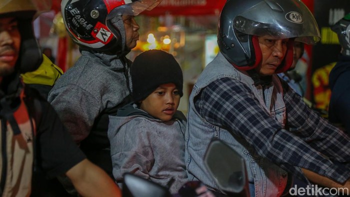 Seorang anak duduk di depan sepeda motor saat keluarga pemudik mengantre di Pelabuhan Ciwandan, Minggu (15/3/2026).