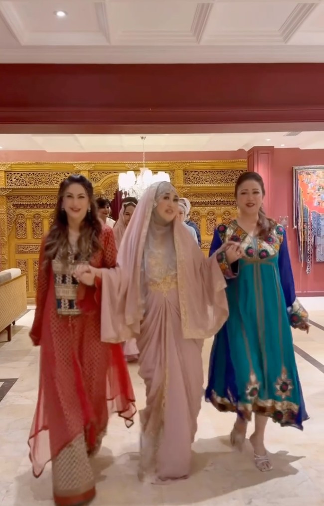 Diana tampil kenakan abaya berwarna merah. Rambut panjangnya tampak dibiarkan terurai. Foto: Instagram/@rieta_amilia