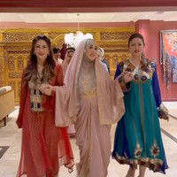 Diana tampil kenakan abaya berwarna merah. Rambut panjangnya tampak dibiarkan terurai. Foto: Instagram/@rieta_amilia