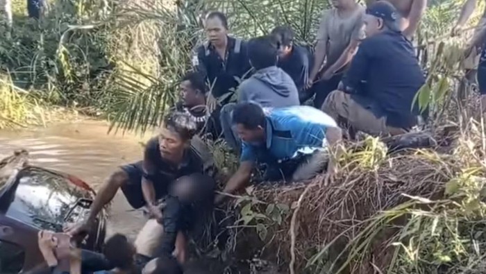 Warga mengevakuasi penumpang mobil Xenia yang masuk ke sungai  di Musi Rawas