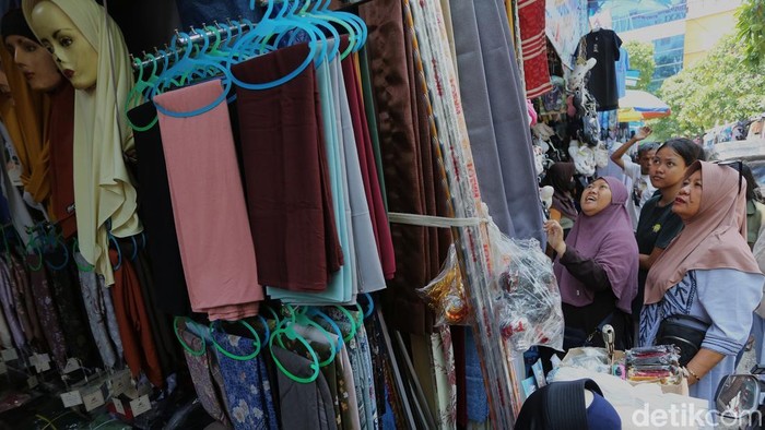 Para pedagang baju Lebaran melayani pengunjung di Pasar Jatinegara, Jakarta, Senin (16/3/2026).