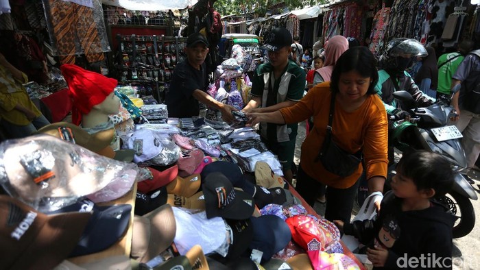 Para pedagang baju Lebaran melayani pengunjung di Pasar Jatinegara, Jakarta, Senin (16/3/2026).