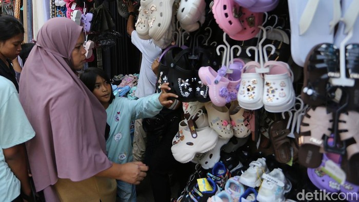 Para pedagang baju Lebaran melayani pengunjung di Pasar Jatinegara, Jakarta, Senin (16/3/2026).