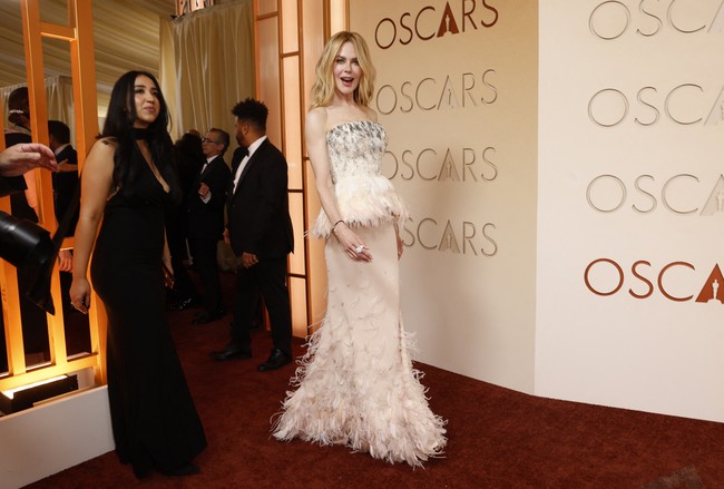 Nicole Kidman tampil memikat dalam gaun Chanel berwarna blush pink. Desain strapless tersebut dilengkapi bodice dan rok dengan detail bulu halus, menciptakan tampilan glamor namun tetap lembut. Foto: REUTERS/DANIEL COLE